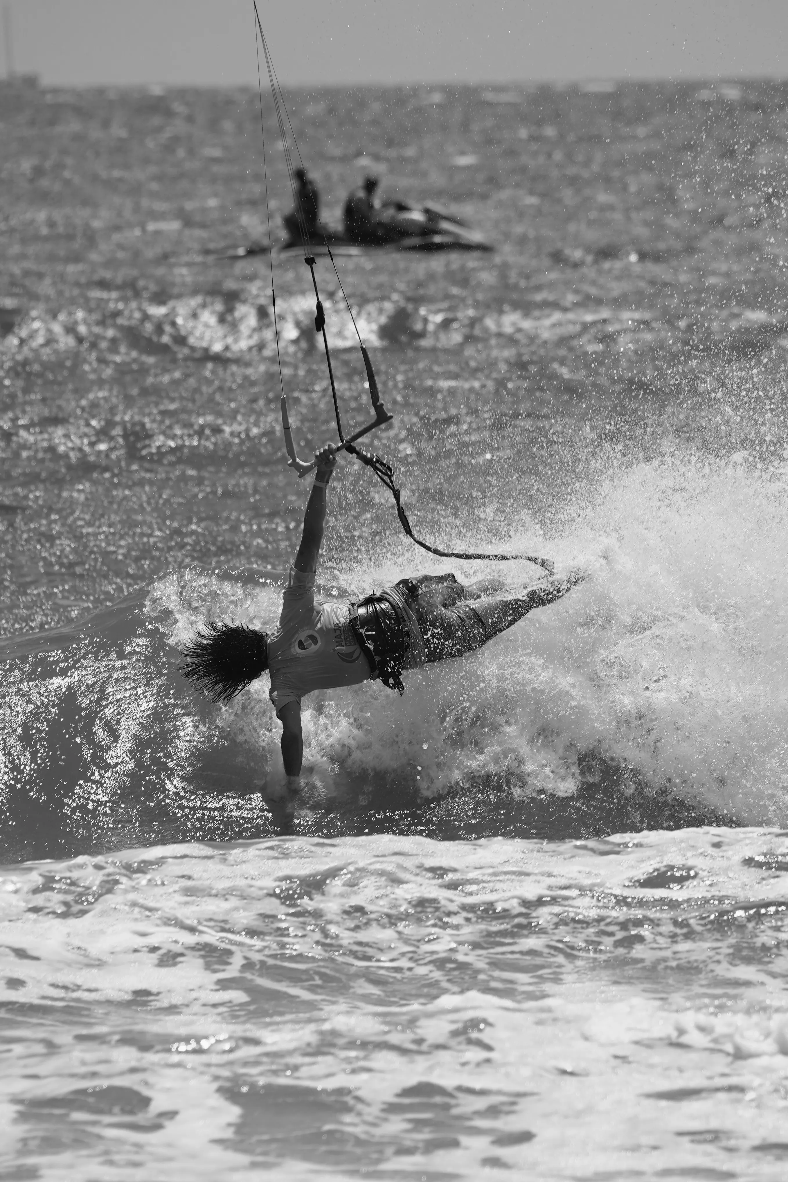 Acción de kitesurf con estela de agua, blanco y negro